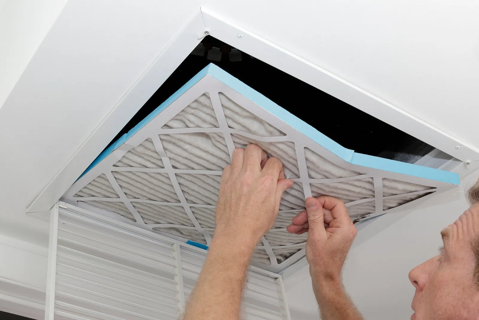 Technician cleaning an air duct vent in a Humble home
